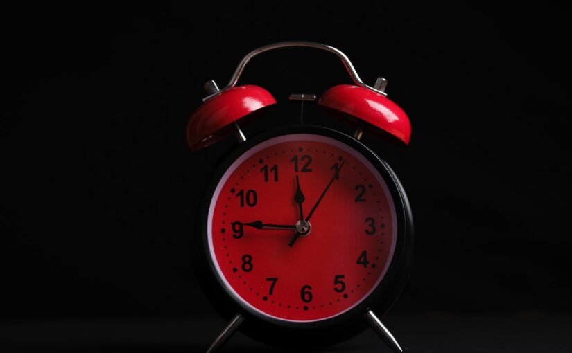 red alarm clock on black background