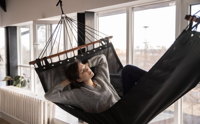 tired woman sleeping in cozy hammock in flat
